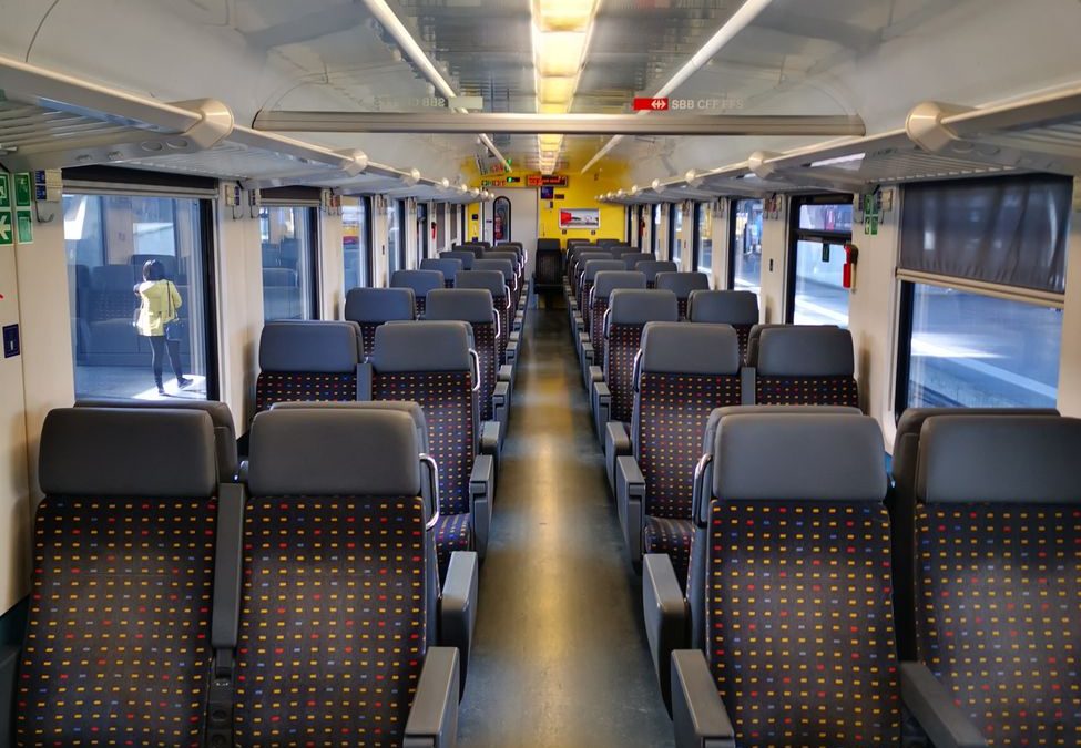 An empty modern train interior with blue seats and bright lighting, perfect for travel concept.