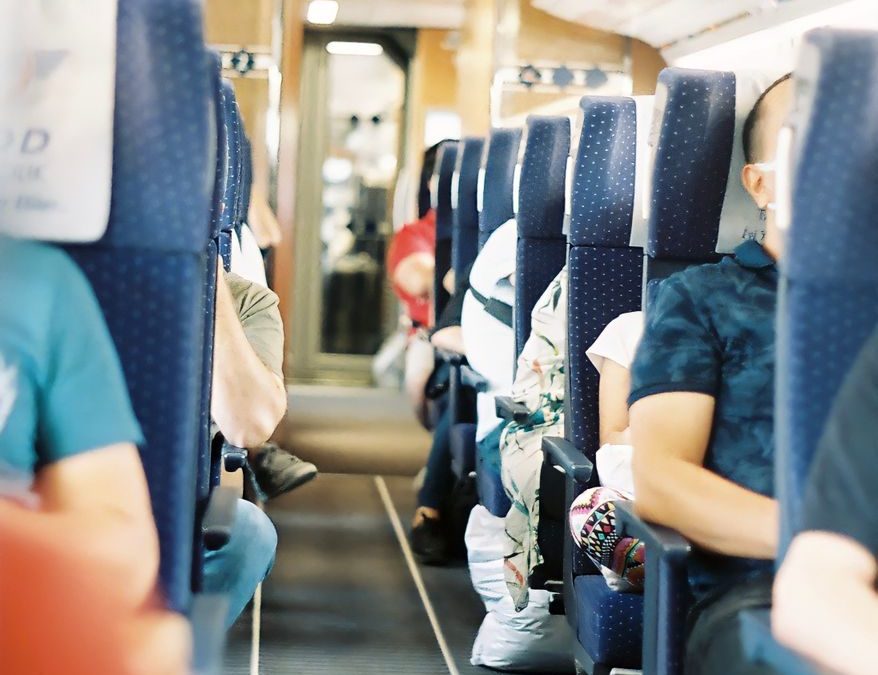 Passengers seated inside a modern train, showcasing comfortable seating and travel atmosphere.