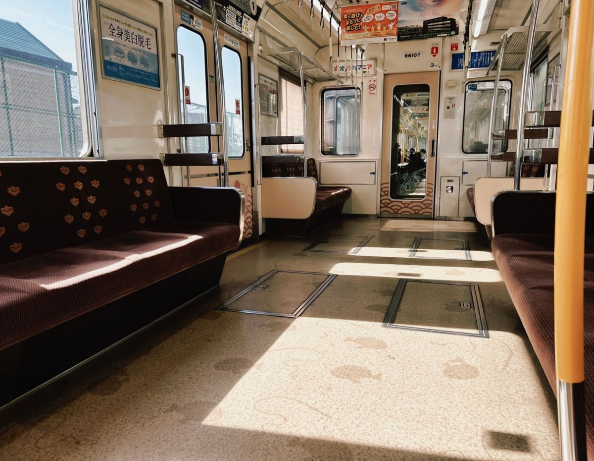 Interior of an empty train in Kyoto, Japan with sunlight streaming in, showcasing urban travel.