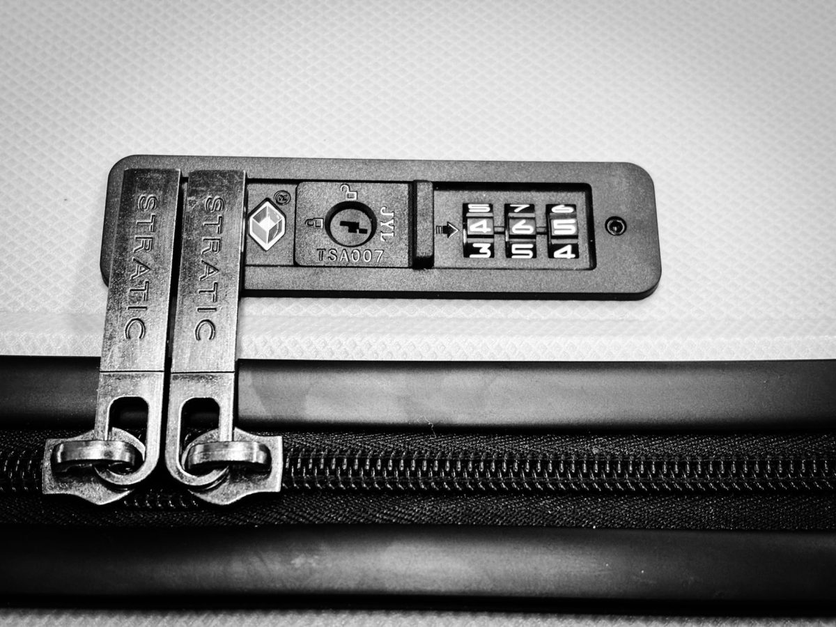 Close up image of a TSA compatible zipper lock on a suitcase, ensuring travel security.
