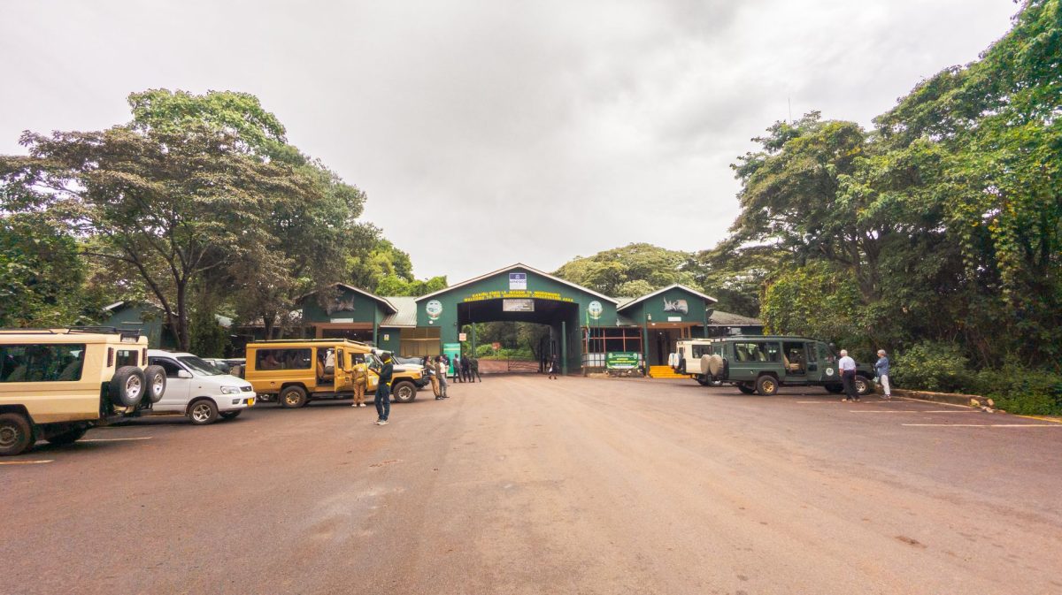 Safari vehicles at the entrance of Arusha National Park in Tanzania.