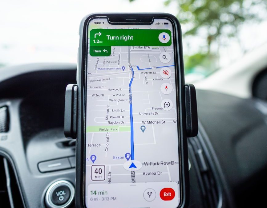 Close up of a smartphone with GPS navigation app mounted on car dashboard.
