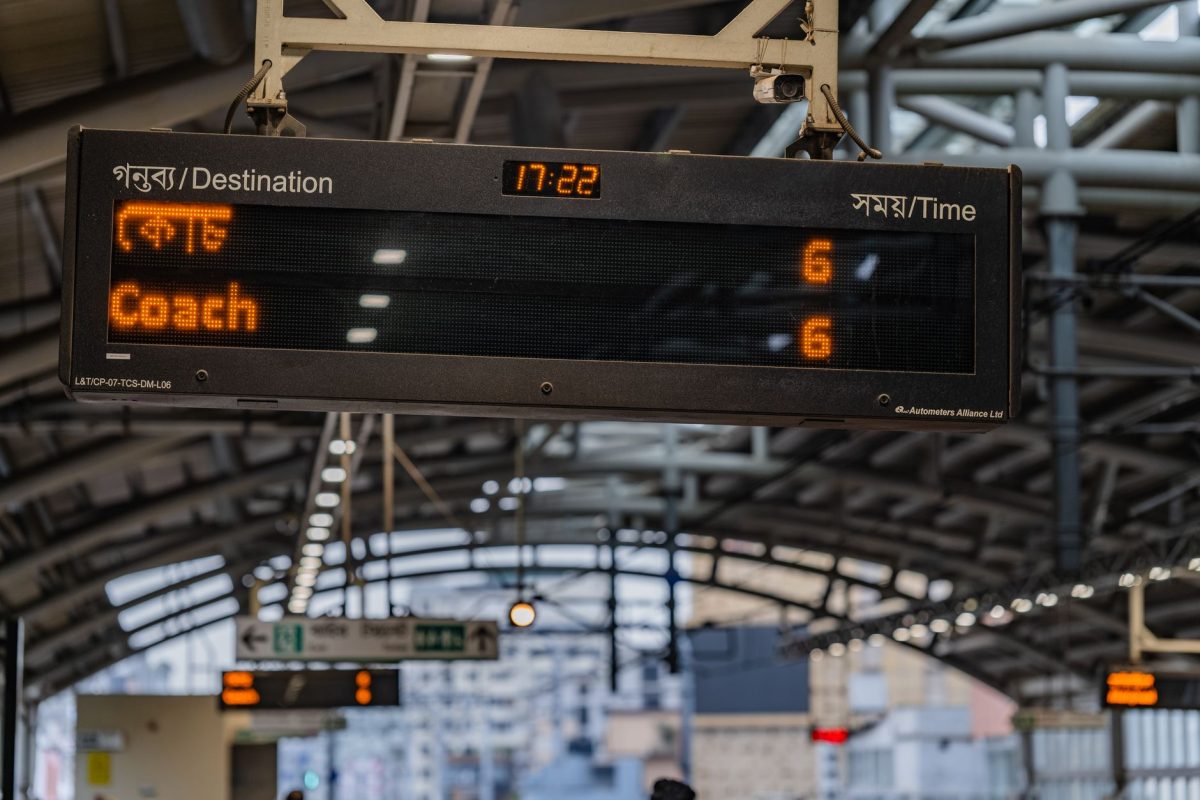 View of a digital display board showing schedule details at a train station in Dhaka, Bangladesh.