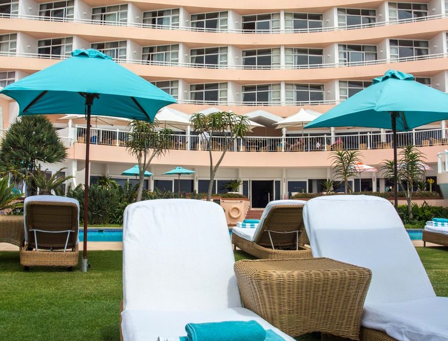 Relax by the pool with elegant wicker lounge chairs at a luxury South African resort.