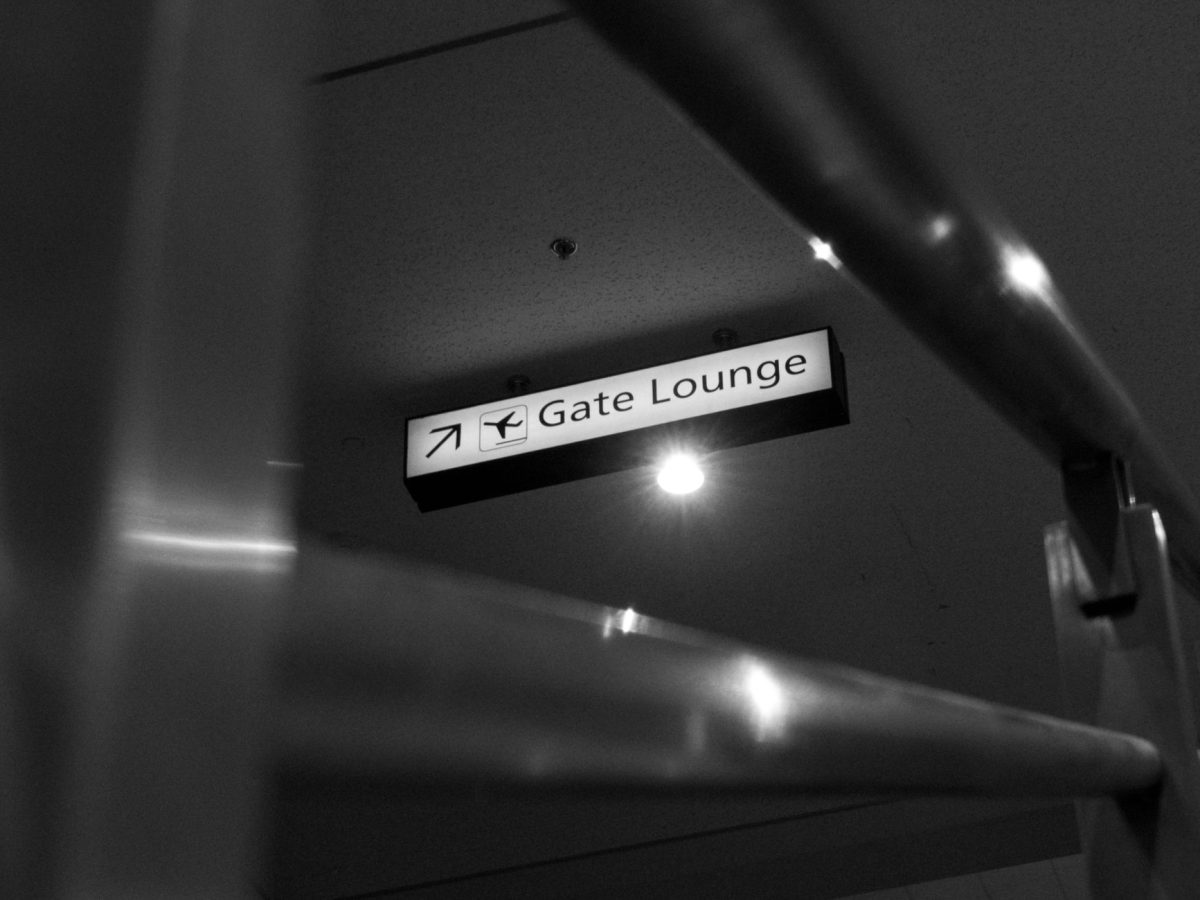 Monochrome photo of a gate lounge sign at the airport with modern design elements.