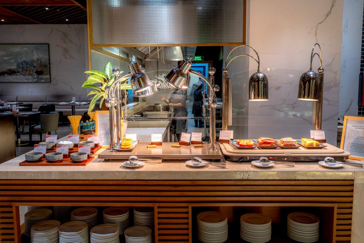 Elegant buffet setup in a modern restaurant with stylish tableware and lighting.