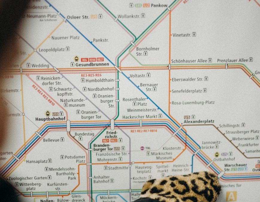 Close up of a gloved hand pointing at a Berlin metro map, highlighting navigation and travel.