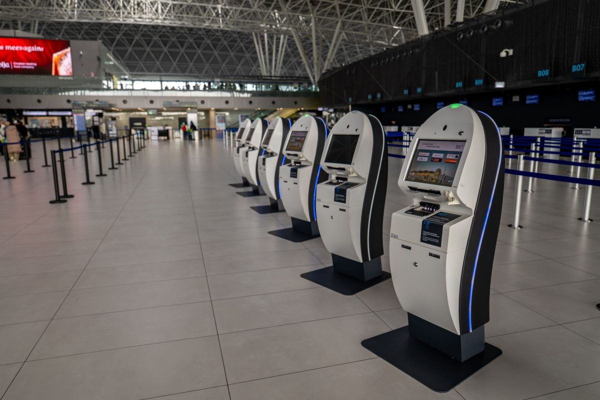 Wide view of an airport terminal in Zagreb featuring self service check in kiosks.