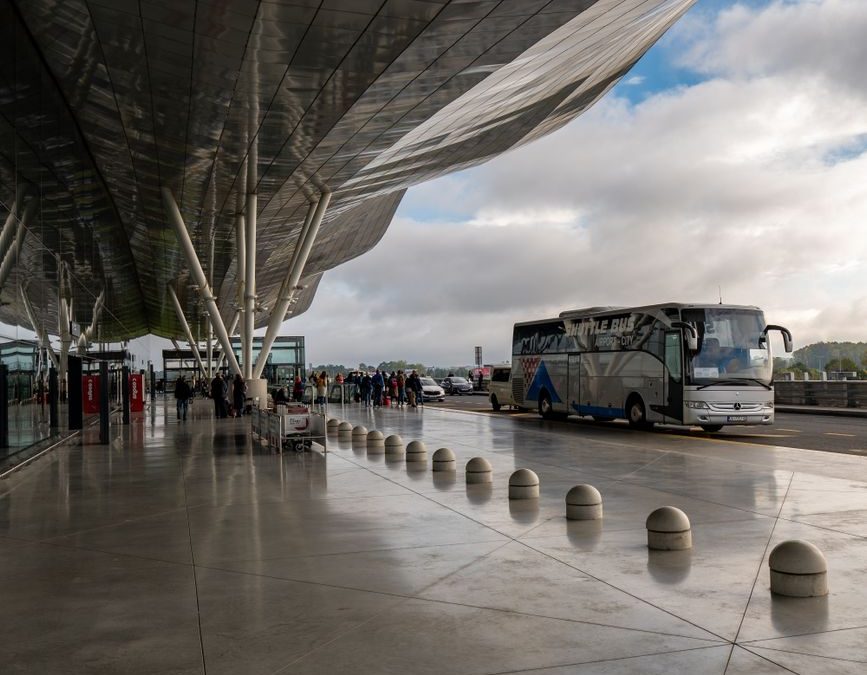 Bus terminal at Zagreb Airport showcasing modern architecture and traveling passengers.