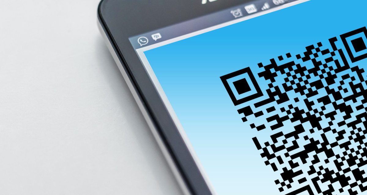 High resolution close up of a smartphone displaying a QR code on its screen.