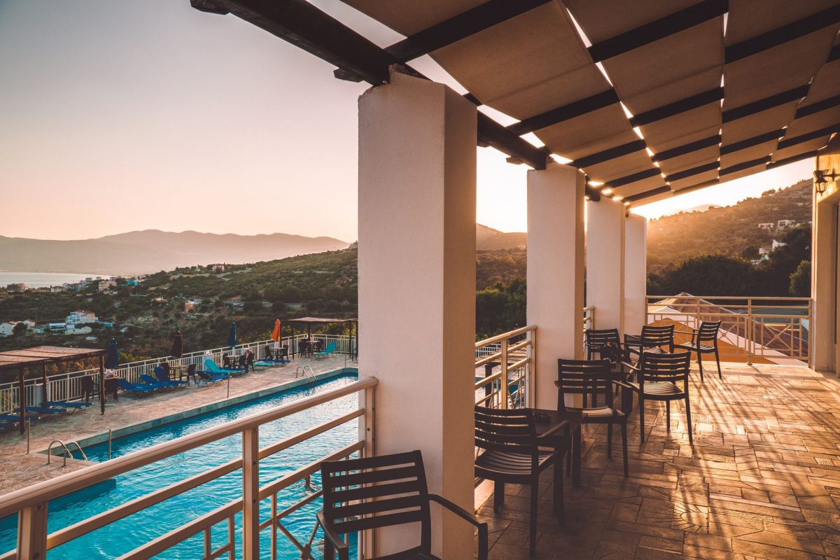 Charming resort patio view with pool and sunset over mountains, creating a cozy and tranquil atmosphere.