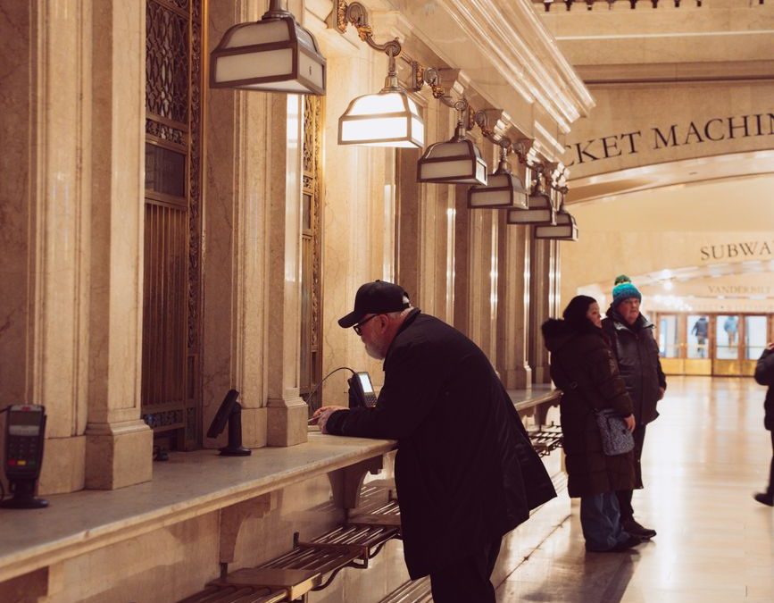 People at a vintage ticket counter in Grand Central Terminal, New York City.