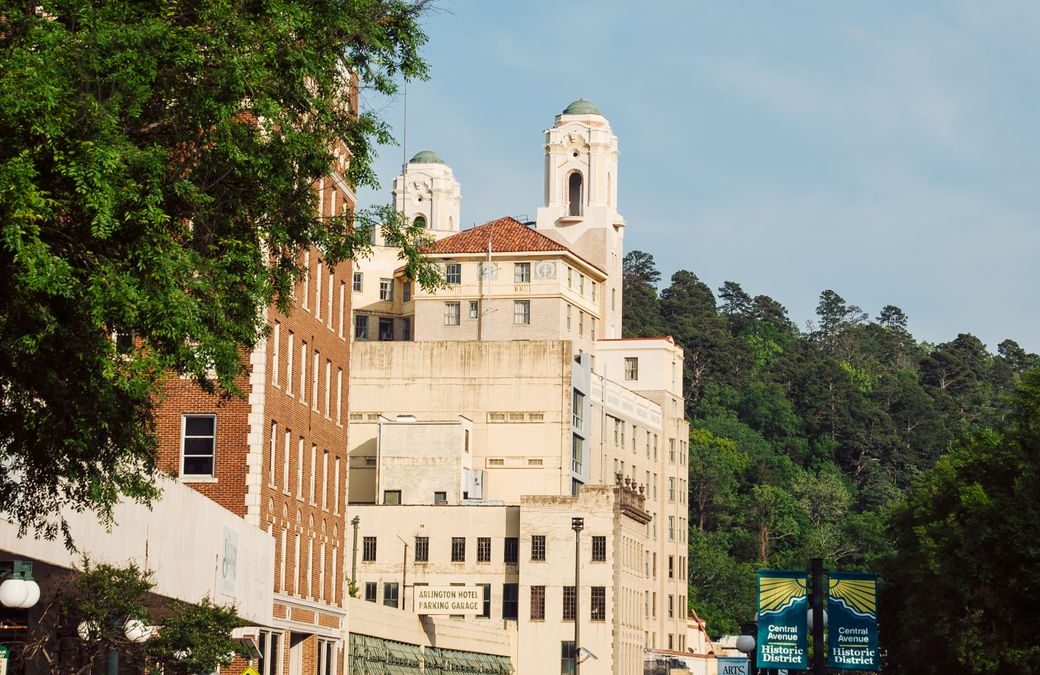 Charming urban street scene featuring historic buildings and lush greenery under a clear sky.