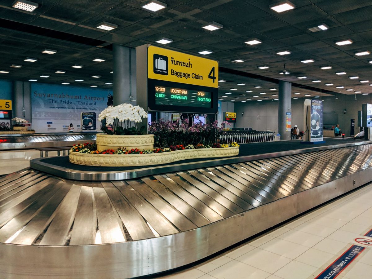 5 Airport Signs Travelers Misread Right When Time Gets Tight 3 Modern baggage claim area at Suvarnabhumi Airport in Bangkok with luggage carousel and signage.