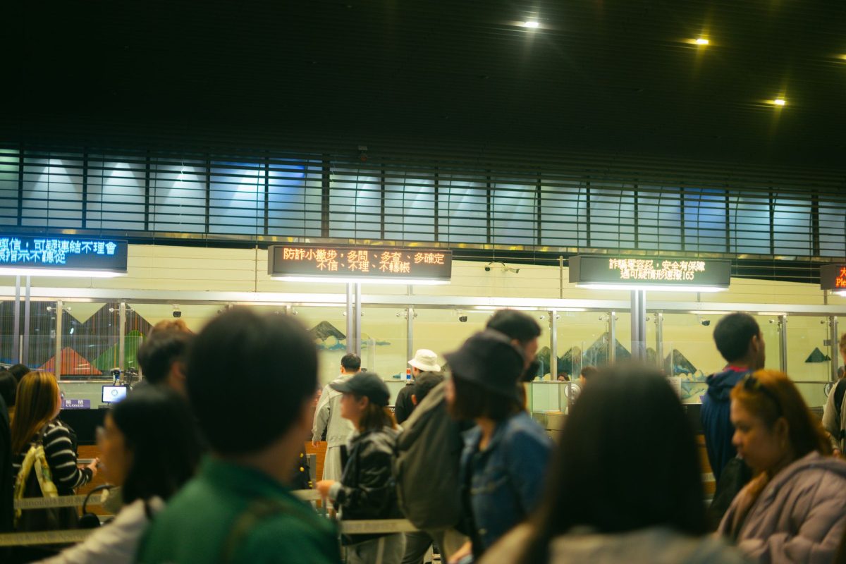 5 Airport Signs Travelers Misread Right When Time Gets Tight 4 Crowded airport check in area with people queueing and visible flight information signs.