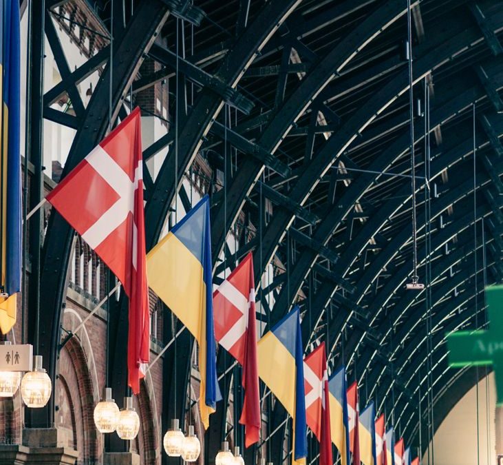 Colorful display of Danish and other flags inside Copenhagen Central Station.