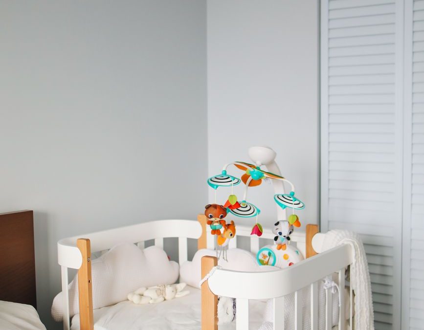 5 Hotel Booking Details Families Often Wish They Checked Before Arrival 2 Interior of cozy light bedroom with white cute wooden crib locating in corner between bed and built in wardrobe during morning