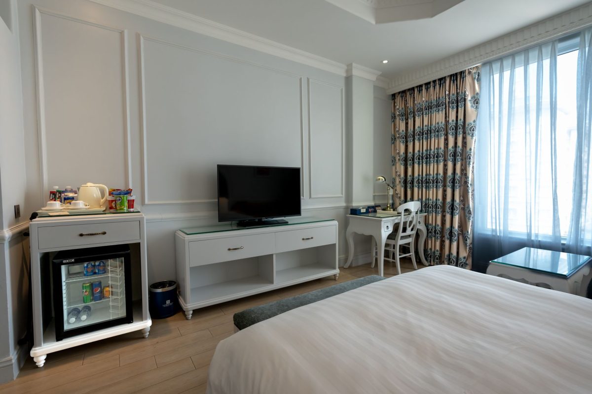 5 Hotel Booking Details Families Often Wish They Checked Before Arrival 4 Bright and stylish hotel bedroom with TV, minibar, and cozy furnishings.