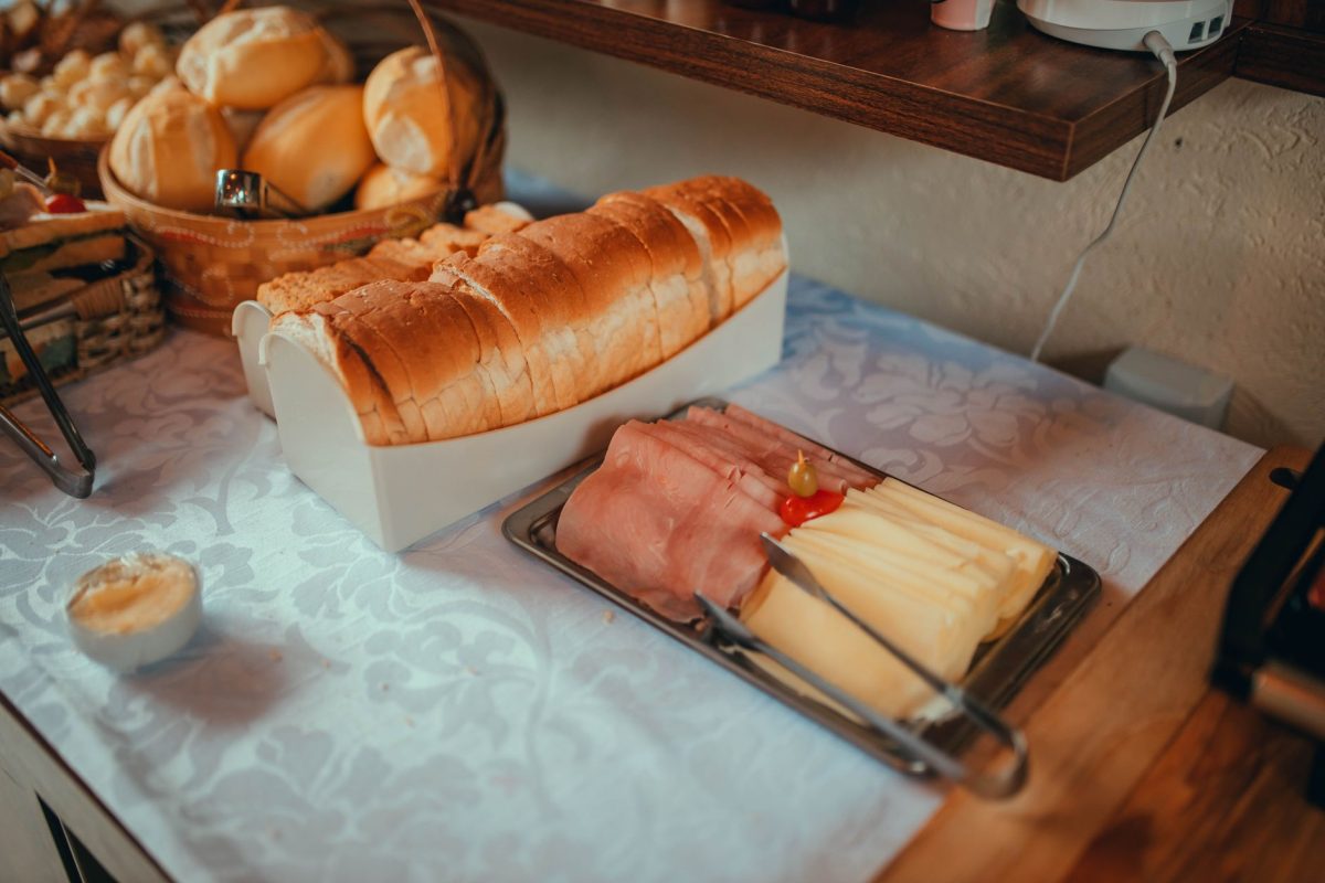 5 Hotel Booking Details Families Often Wish They Checked Before Arrival 5 A delightful continental breakfast setup featuring sliced bread, ham, cheese, and rolls on a linen covered table.