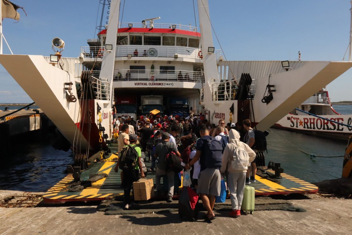 Crowd of travelers boarding a ferry at Lucena City terminal in the Philippines.