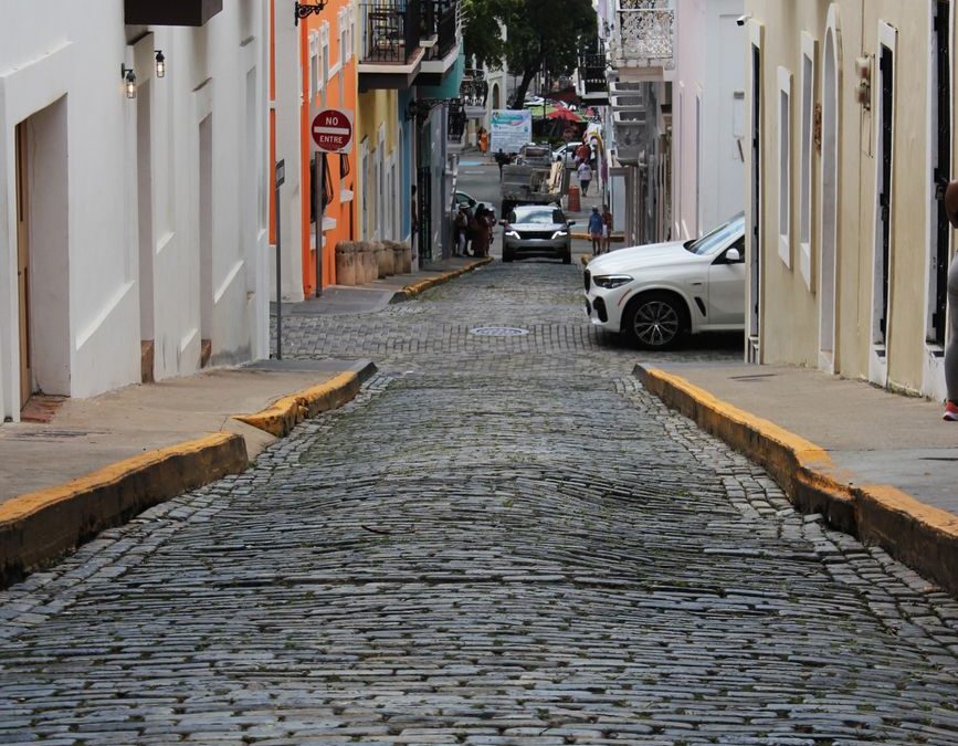 A picturesque cobblestone street lined with colorful buildings in an urban environment.