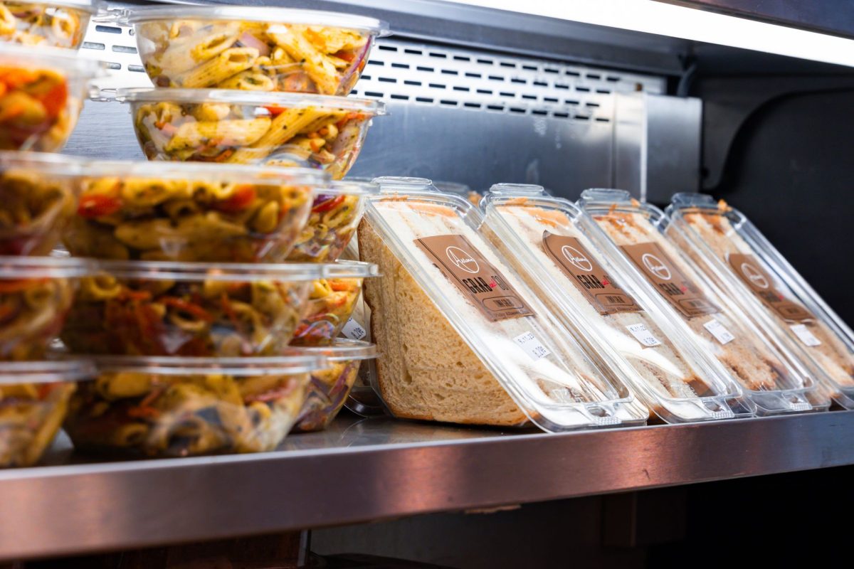 Delicious ready to eat pasta salads and sandwiches displayed in a store fridge.
