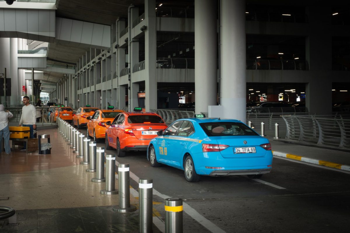 5 Airport Signs Travelers Keep Missing and Regret Later 5 Vibrant taxis lined up at Istanbul Airport arrival terminal with passengers and drivers interacting.