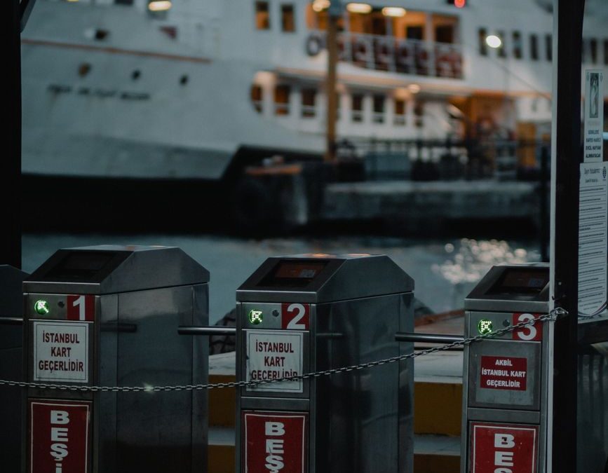 View of Beşiktaş ferry terminal entrance in Istanbul with ferryboat in background during dusk.