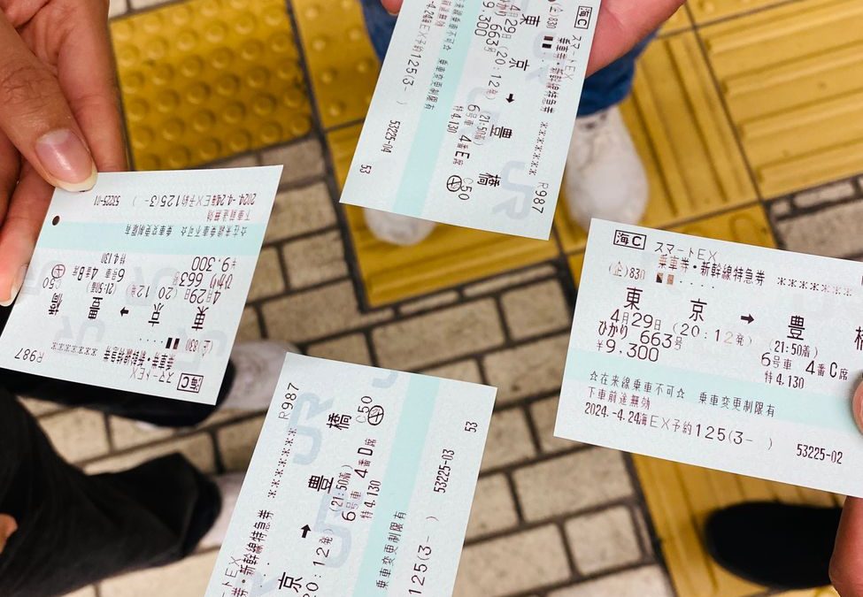 5 Train Station Mistakes That Make Trips Go Sideways Fast 3 Four people holding train tickets at a Tokyo station, capturing a moment of travel.