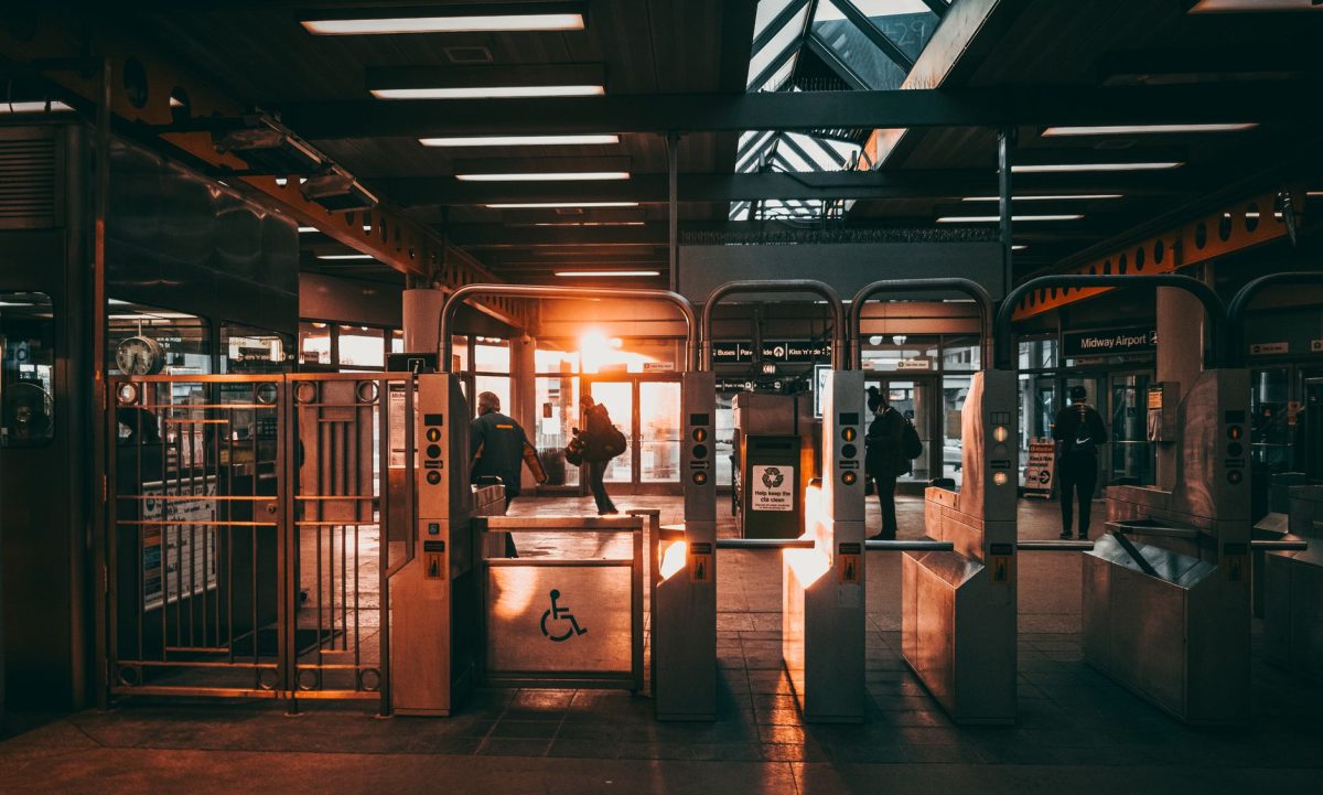 5 Train Station Mistakes That Make Trips Go Sideways Fast 4 Commuters at an urban train station with warm sunlight streaming through the gates.