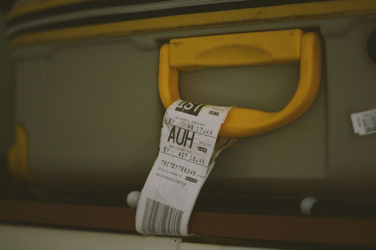 5 Check-In Counter Questions That Can Save Your First Vacation Day 1 Close up of a yellow suitcase handle with a visible travel tag and barcode, ideal for travel themes.