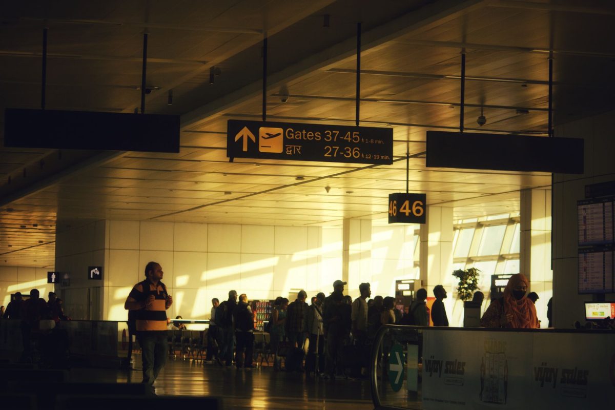 5 Check-In Counter Questions That Can Save Your First Vacation Day 4 Crowded hallways and directional signs guide travelers in Delhi Airport.