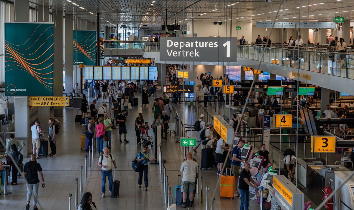 5 Check-In Counter Questions That Can Save Your First Vacation Day 5 Crowds in the departure area of Amsterdam's Schiphol Airport, showcasing bustling travel activity.